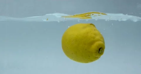 Lemon dropped into water on white background. Citrus in water with bubbles Stock Footage 148683158
