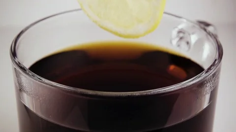 Lemon drops into a glass with tea. Slow motion Stock Footage 75675813