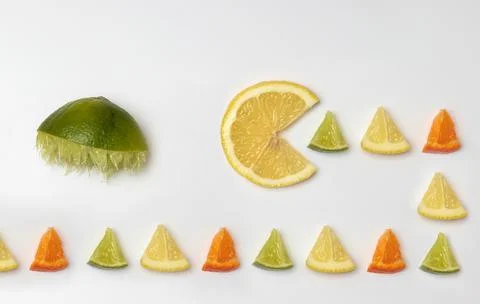 Lemon eats pieces hunted by lime. Pac man minimal citrus fruit flat lay concept Stock-Fotos