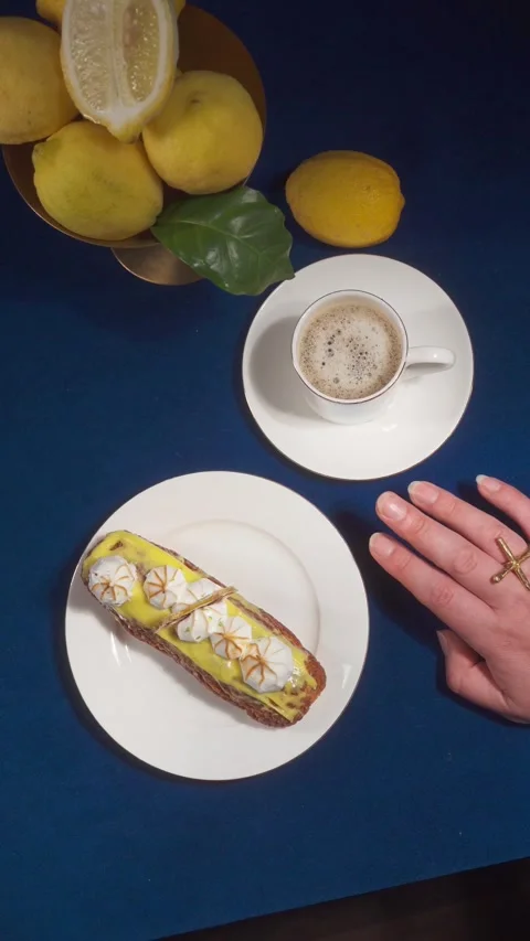 Lemon Eclair Dessert and Coffee Serving on Blue Cafe Table Close Up Vertical Stock Footage 335422314