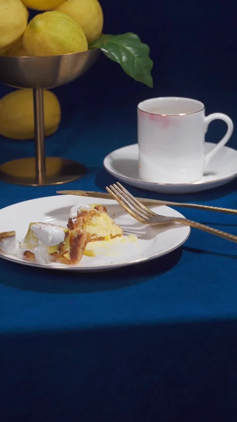 Lemon Eclair Dessert with Coffee Serving on Blue Cafe Table Close Up Vertical Stock Footage 335422298
