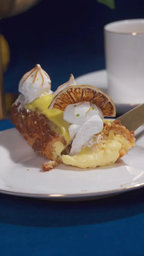 Lemon Eclair Dessert Slice Cutting Close Up on Cafe Table with Coffee Setup Stock Footage 335422282