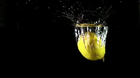 Lemon falling into water super slow motion shot against black background Vídeos de archivo 75290452