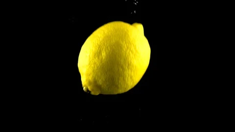 Lemon falls in the water in slow motion. Isolated on black background with alpha Stock Footage 114139836