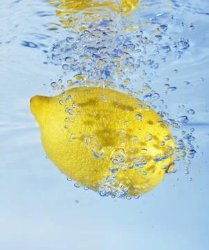 Lemon flows into water Stock Photos