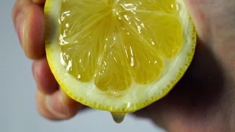 Lemon, a hand squeezes the juice closeup Stock Footage 72252353