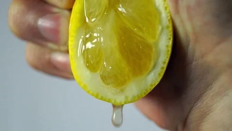 Lemon, a hand squeezes the juice closeup Stock Footage 72252722