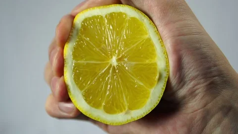 Lemon, a hand squeezes the juice closeup Stock Footage 72460273