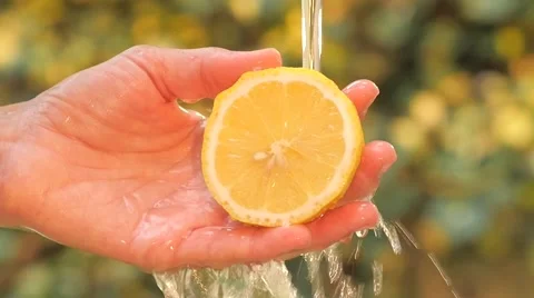 Lemon in hand under flowing water slow motion Stock Footage 41389652
