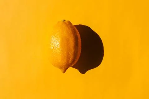 Lemon with a hard shadow on a plain background. the view from the top. blank for 스톡 사진