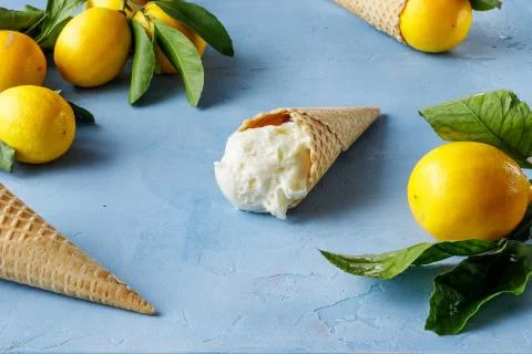 Lemon ice-cream in waffle cone on a light background. Side view. Stock Photos