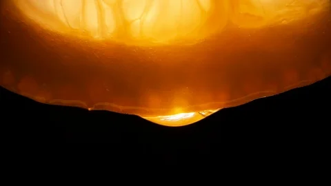 Lemon juice flows from the pulp and drips on a black background, macro video Stock Footage 126317560