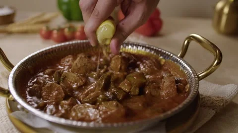 Lemon Juice Squeezed Over Turkish Stew in Metal Dish on Kitchen Table Indoors Stock Footage 345277350
