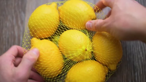 Lemon lemons bundle in mesh bag of grocery store supermarket Stock Footage 336756928