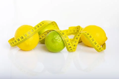 Lemon with lime on the white surface of the table with a tape measure for mea Stock Photos