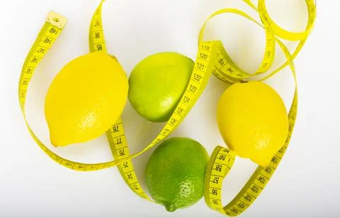 Lemon with lime on the white surface of the table with a tape measure for mea Stock Photos