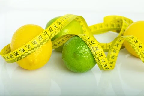 Lemon with lime on the white surface of the table with a tape measure for mea Stock Photos