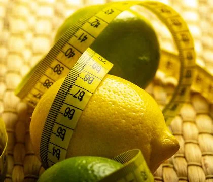 Lemon with lime on the wooden surface of the table with a tape measure for me Stock Photos