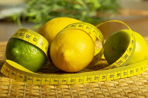 Lemon with lime on the wooden surface of the table with a tape measure for me Stock Photos