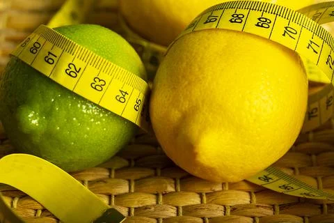 Lemon with lime on the wooden surface of the table with a tape measure for me Stock Photos