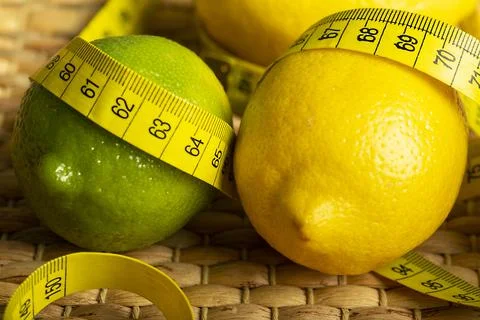 Lemon with lime on the wooden surface of the table with a tape measure for me Stock Photos