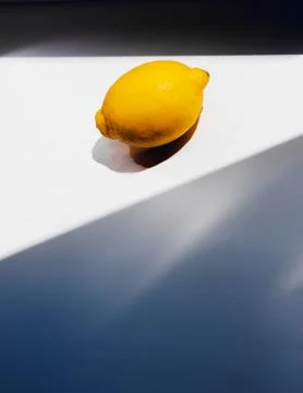 Lemon lying on a white table in the sunlight Stock Photos