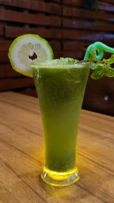 Lemon mint lemonade with ice &amp; a straw in a glass on a table. Stock Footage 285929920