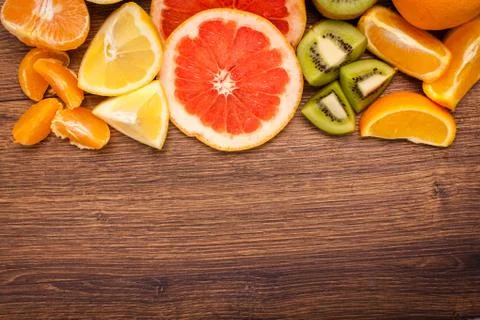 Lemon, orange, kiwi, grapefruit, mandarin on a wooden surface. arrangement .. Stock Photos