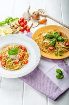Lemon pasta with cherry tomatoes, basil and nuts Stock Photos