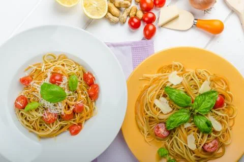 Lemon pasta with cherry tomatoes, basil and nuts Stock Photos
