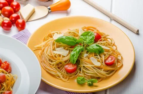 Lemon pasta with cherry tomatoes, basil and nuts Stock Photos