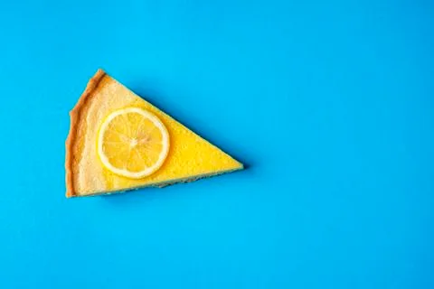 Lemon pie slice on a blue background. Above view and copy space. Stock Photos