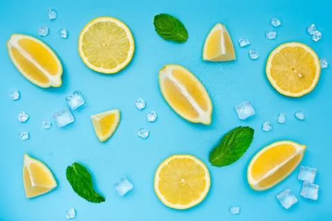 Lemon set with ice cubes and mint leaves on blue background. Stock Photos