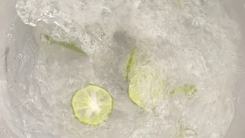 Lemon slice and mint into water swirling slow motion Stock Footage 95075983