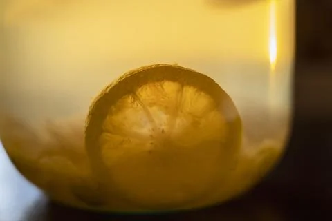 Lemon slice in apple compote in a glass jar on the table, soft evening light 库存照片