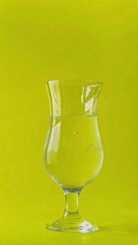 Lemon slice falling into a cocktail glass filled with sparkling mineral water. Stock Footage 338182509
