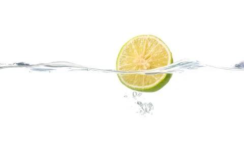 Lemon slice falling in the water, white background Fotos de archivo