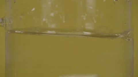 Lemon slice falls into water in SLOW MOTION. Lots of air bubbles rising. Stock Footage 147572664