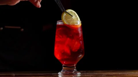 Lemon Slice Garnish Added to Vibrant Red Cocktail with Tweezers Stock Footage 337862571