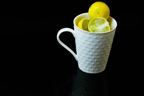 Lemon slice pieces arranged in tea glass closeup black background Stock Photos