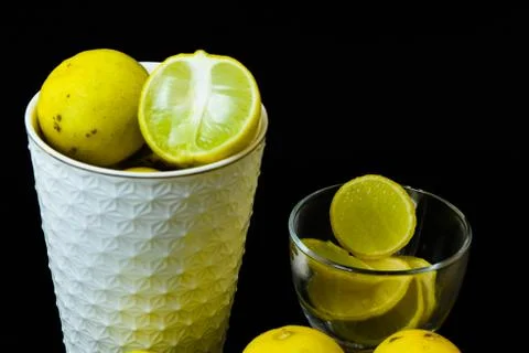 Lemon slice pieces arranged in tea glass closeup black background Stock Photos