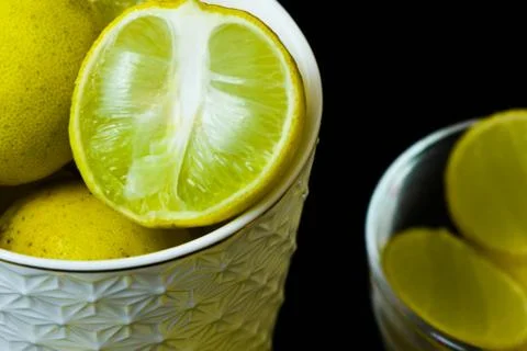 Lemon slice pieces arranged in tea glass closeup black background Stock Photos