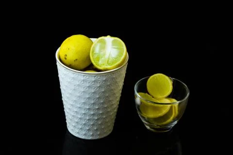 Lemon slice pieces arranged in tea glass closeup black background Stock-Fotos