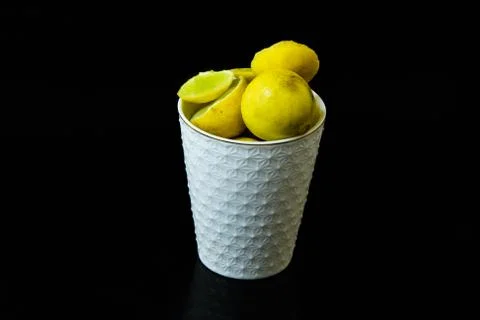 Lemon slice pieces arranged in tea glass closeup black background Stock Photos