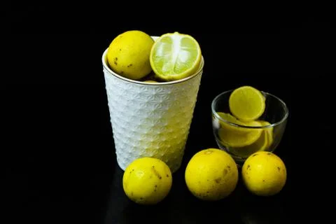 Lemon slice pieces arranged in tea glass closeup black background Stock Photos