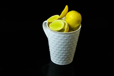 Lemon slice pieces arranged in tea glass closeup black background Stock Photos