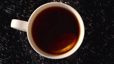 Lemon slice swims in black tea in white cup on knitted background. Hot drink, Stock Footage 119305843