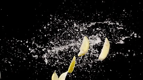 Lemon slice with water droplets collide on black background  super slow motion Stock Footage 116959710