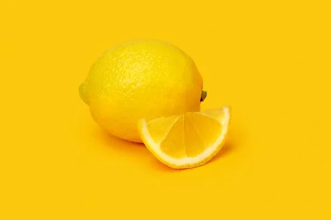 Lemon with slice on yellow background Stock Photos