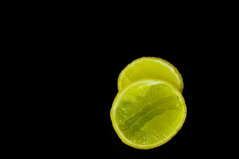 Lemon slices on black isolated background Stock Photos